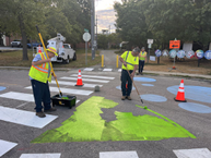 Pictures shows Public Works employees painting the new Roberson Street crosswalk